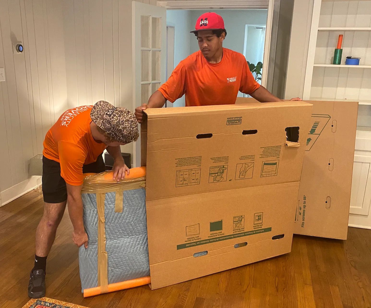Two movers packing furniture