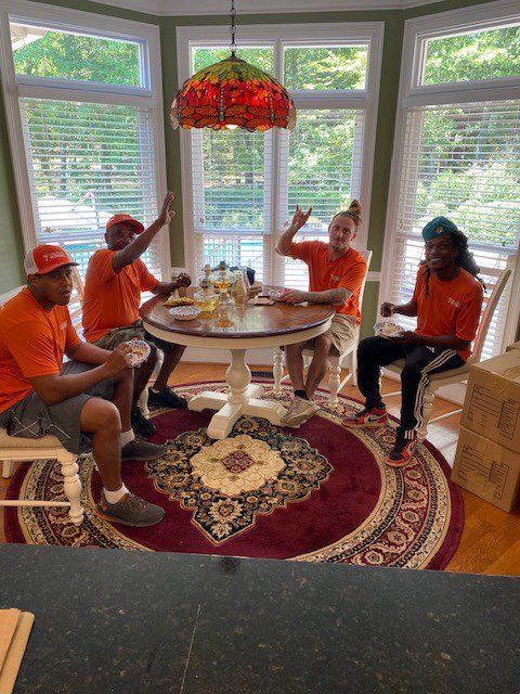 Four people in orange shirts sit around a table