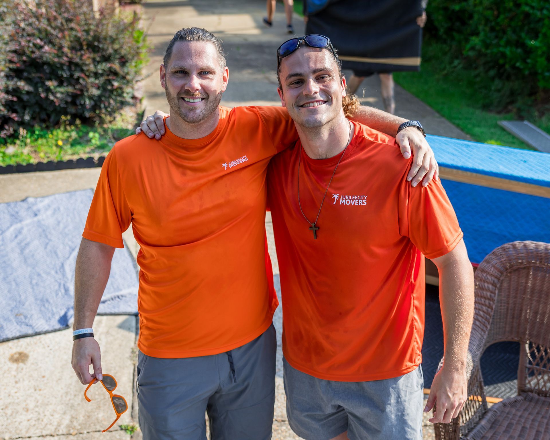 Two men smiling in orange shirts