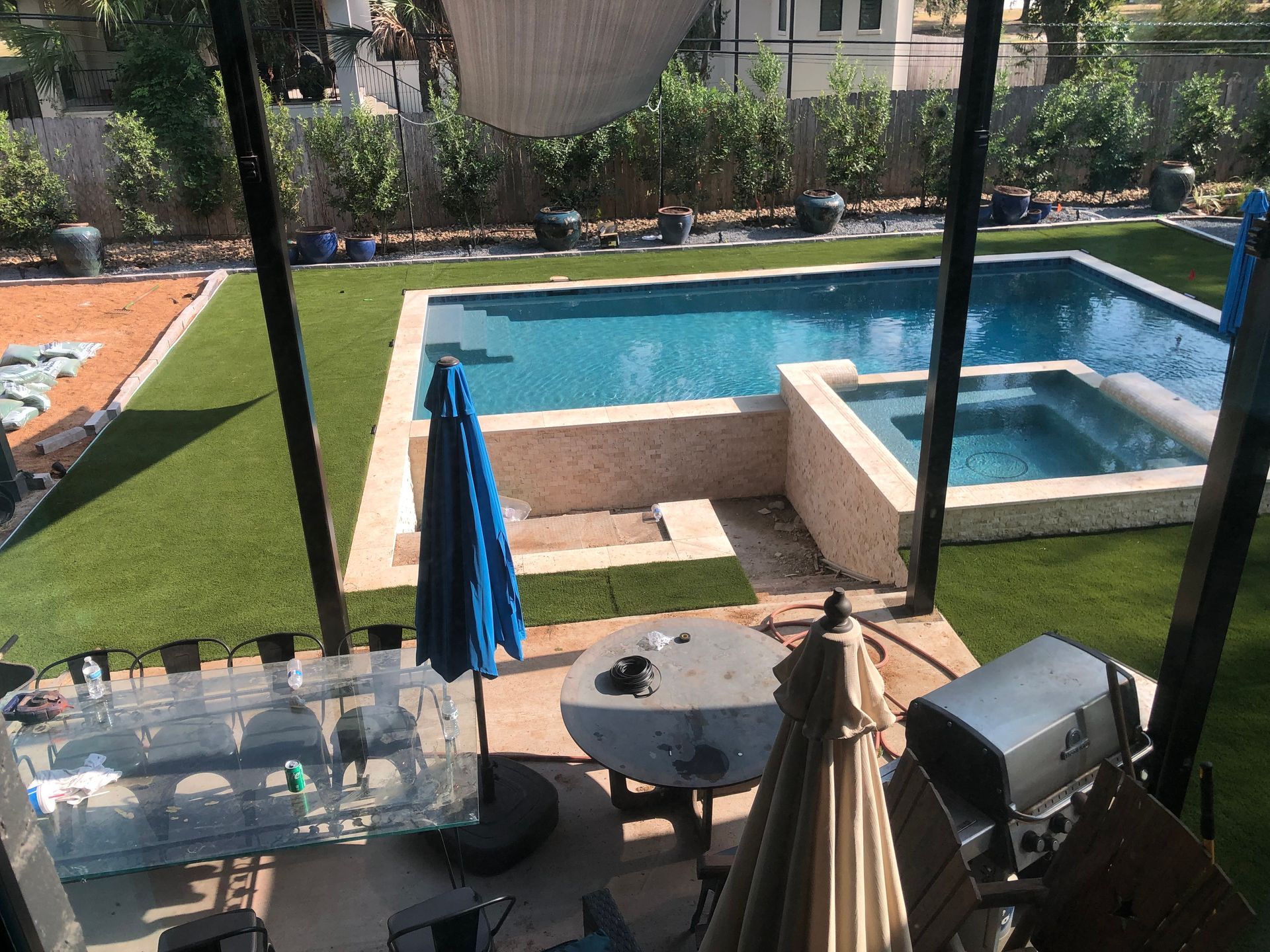 Backyard with pool, hot tub, patio furniture, and artificial turf.