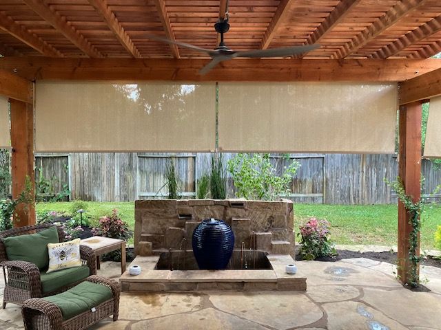 Outdoor patio with a fountain, seating area, and retractable shades.