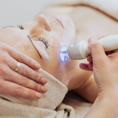 A woman is getting a facial treatment at a beauty salon.