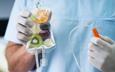 A doctor is holding a bag of fruit in his hands.