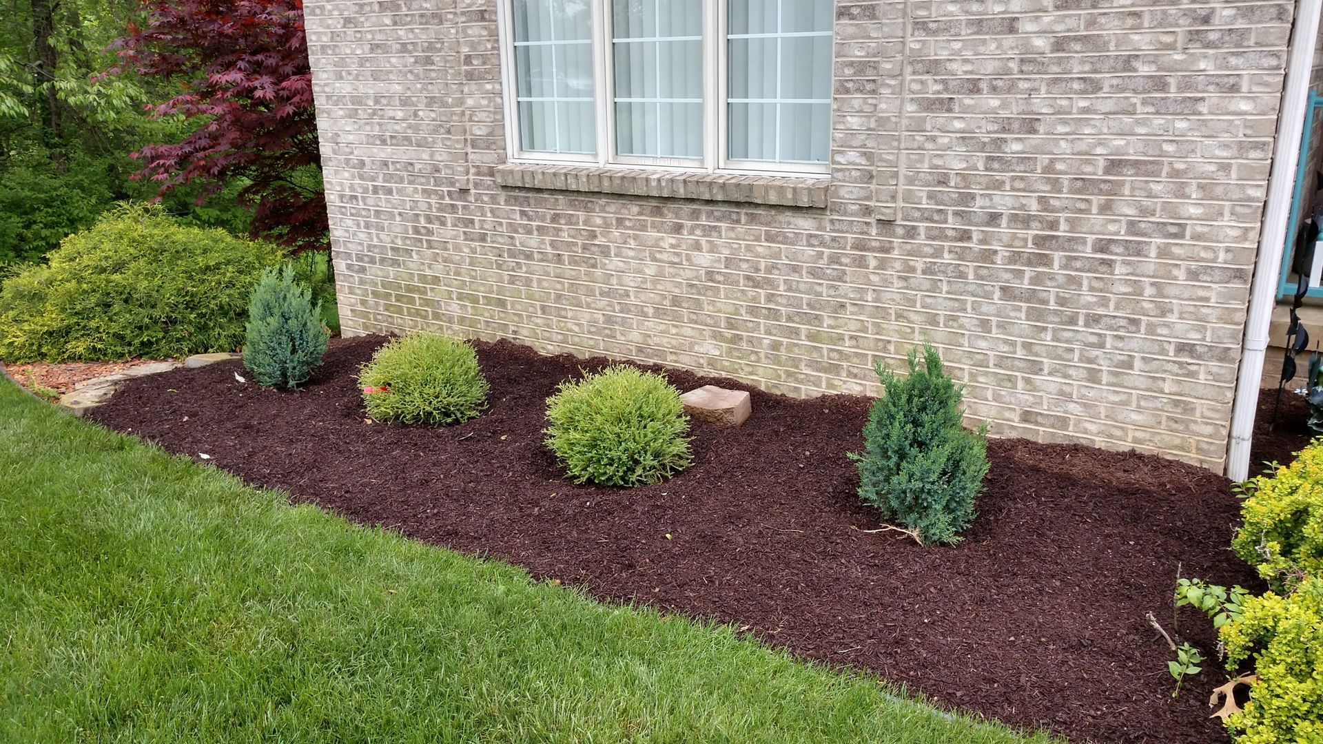 A brick house with a garden in front of it.