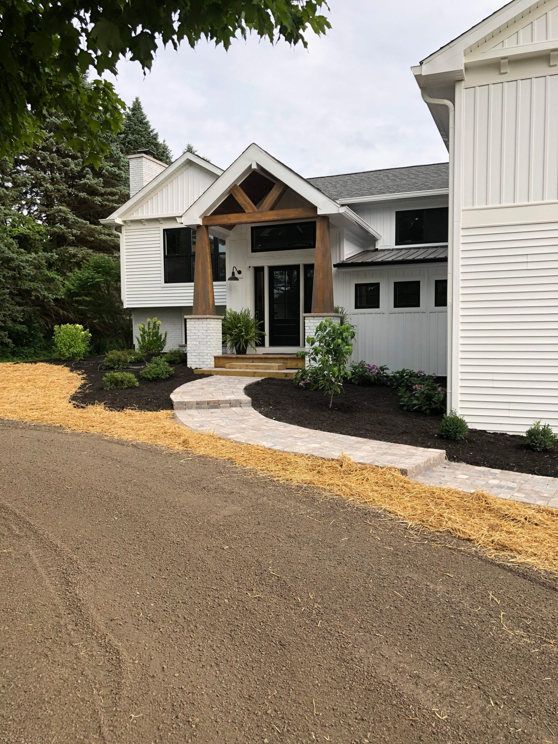 A large white house with a walkway leading to the front door.