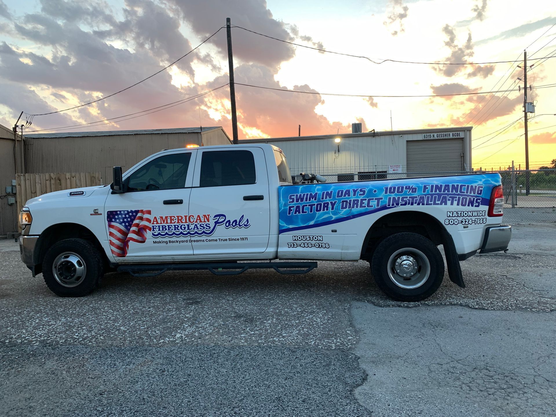 White work truck with company logos parked; sunset in the background.