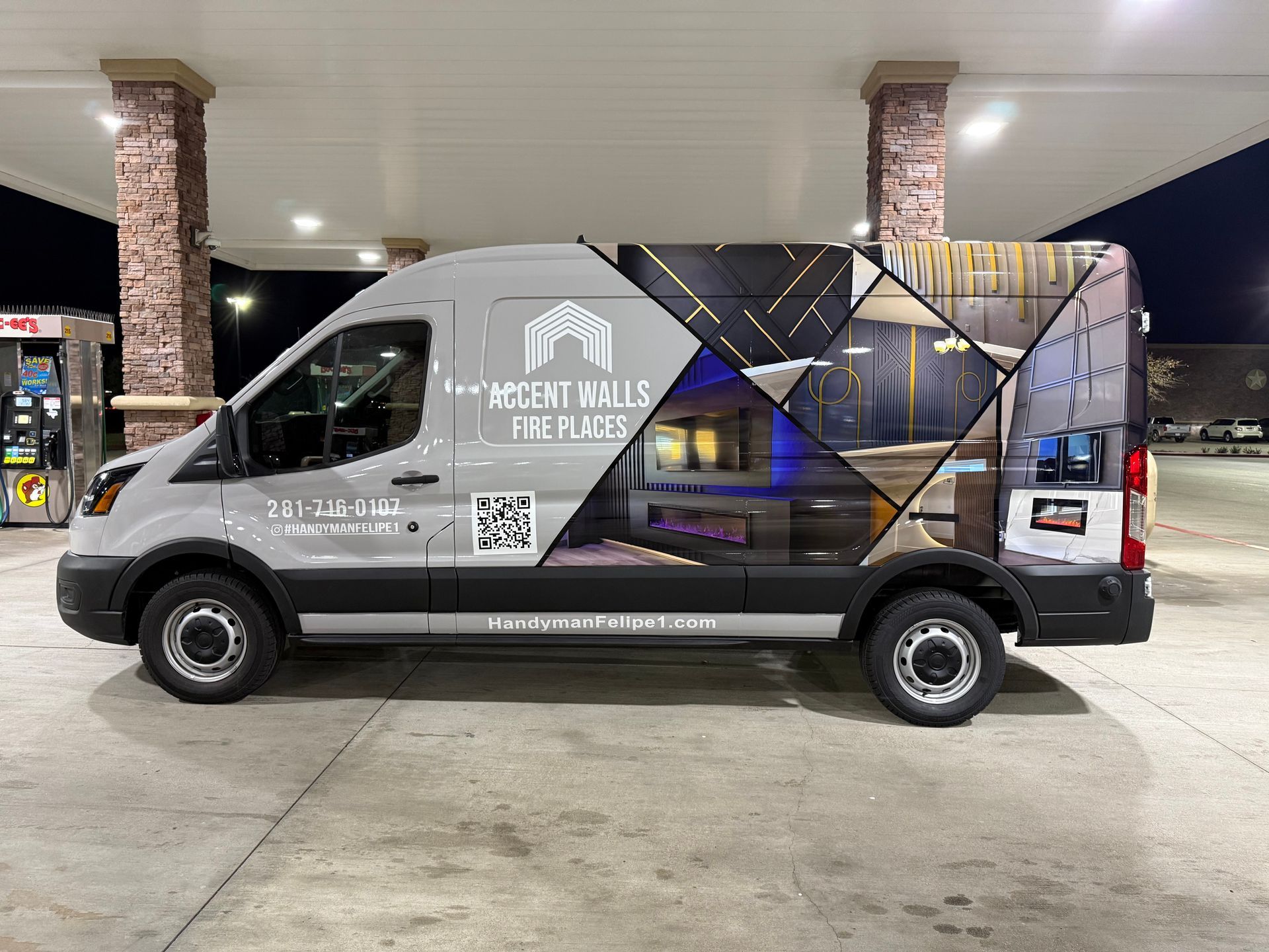 Gray van with company logo and interior design images parked at a gas station.