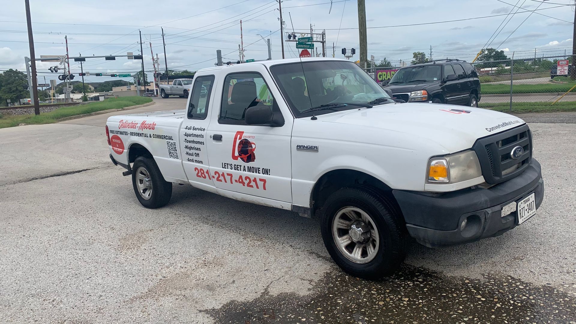 White Ford Ranger pickup truck parked on a paved lot with service logo on the door.