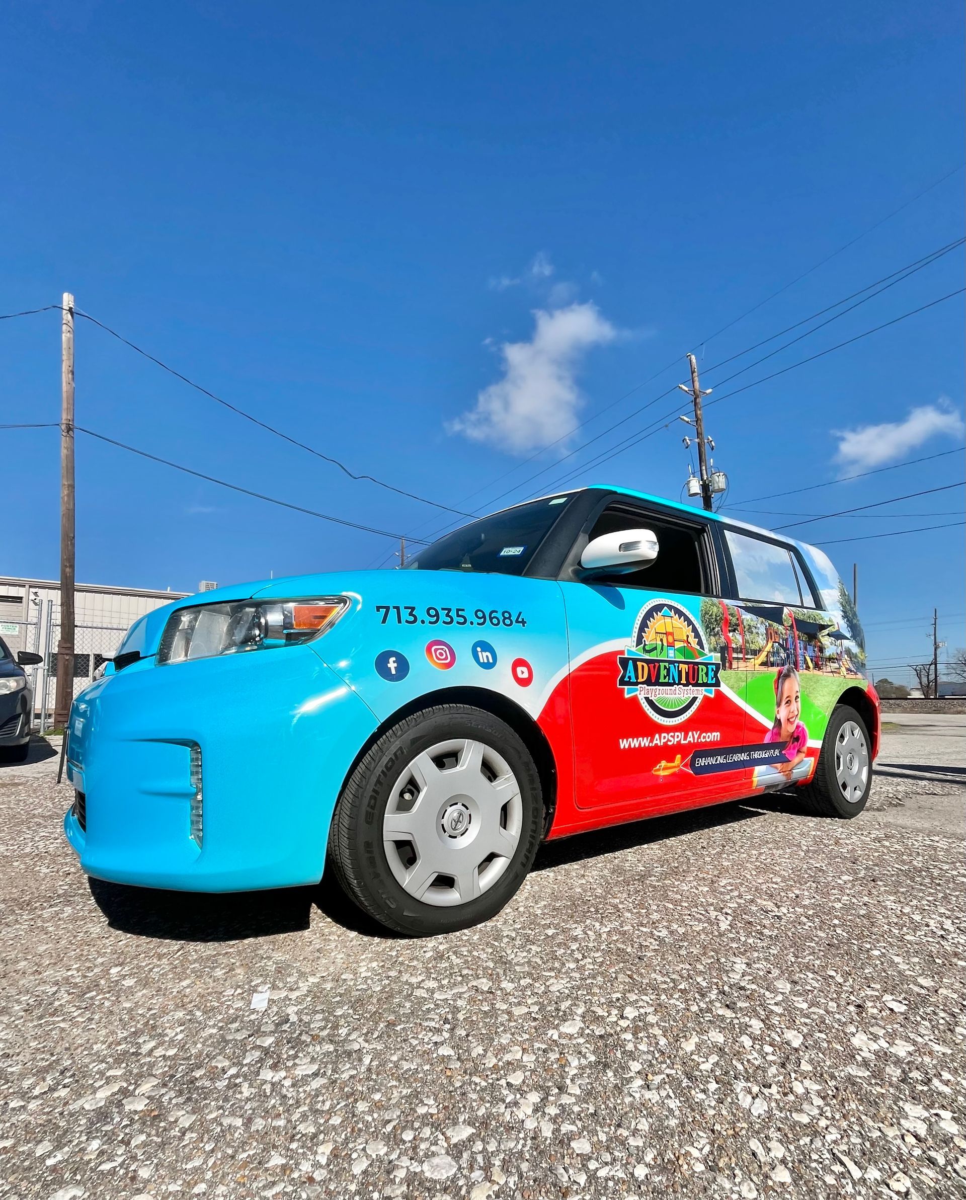 Blue, red, and green wrapped Scion XB, advertising 