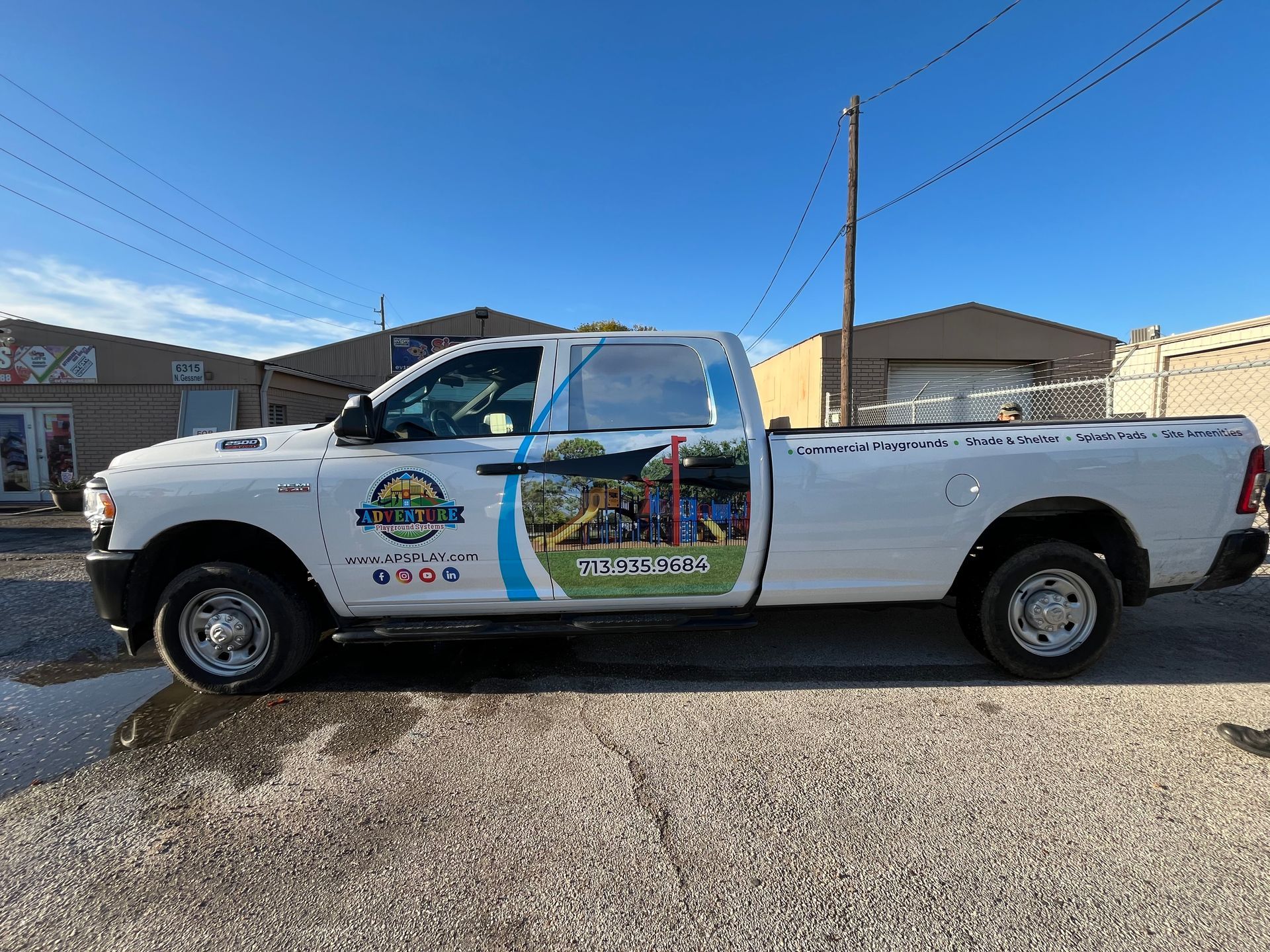 White pickup truck with company logo parked outside a building.
