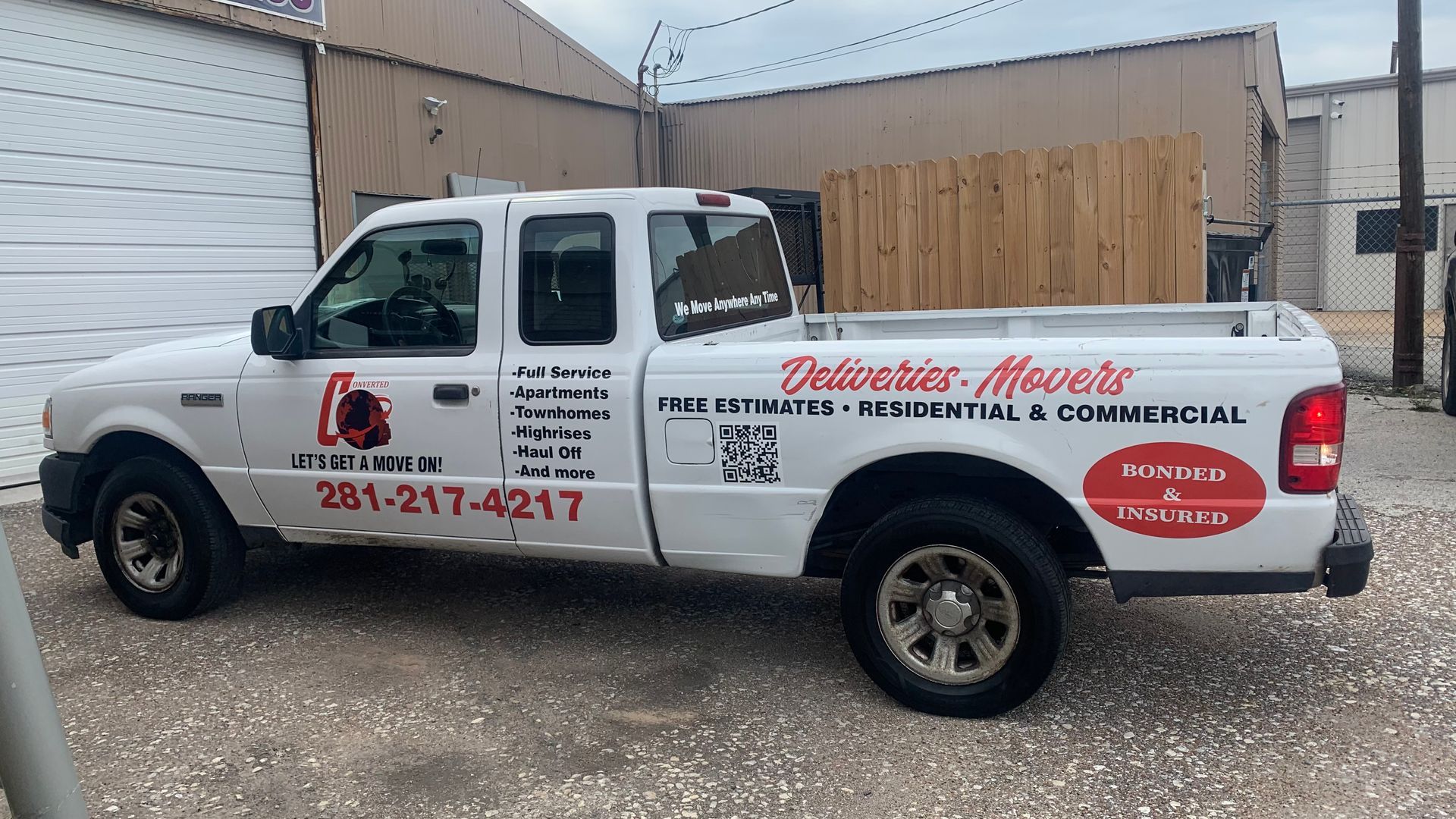 White pickup truck with business decals, parked outdoors.