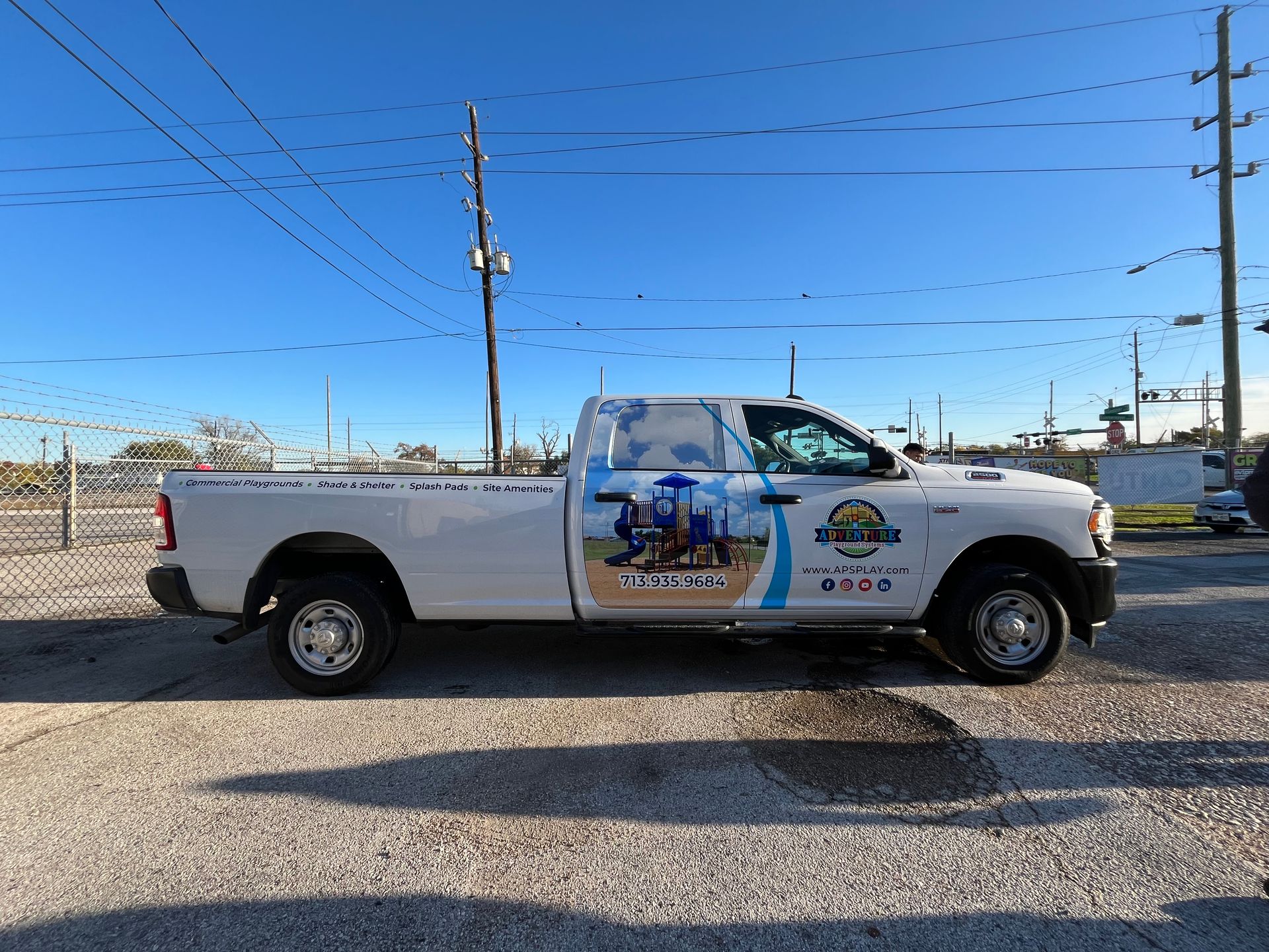 White work truck with company graphics parked outdoors.
