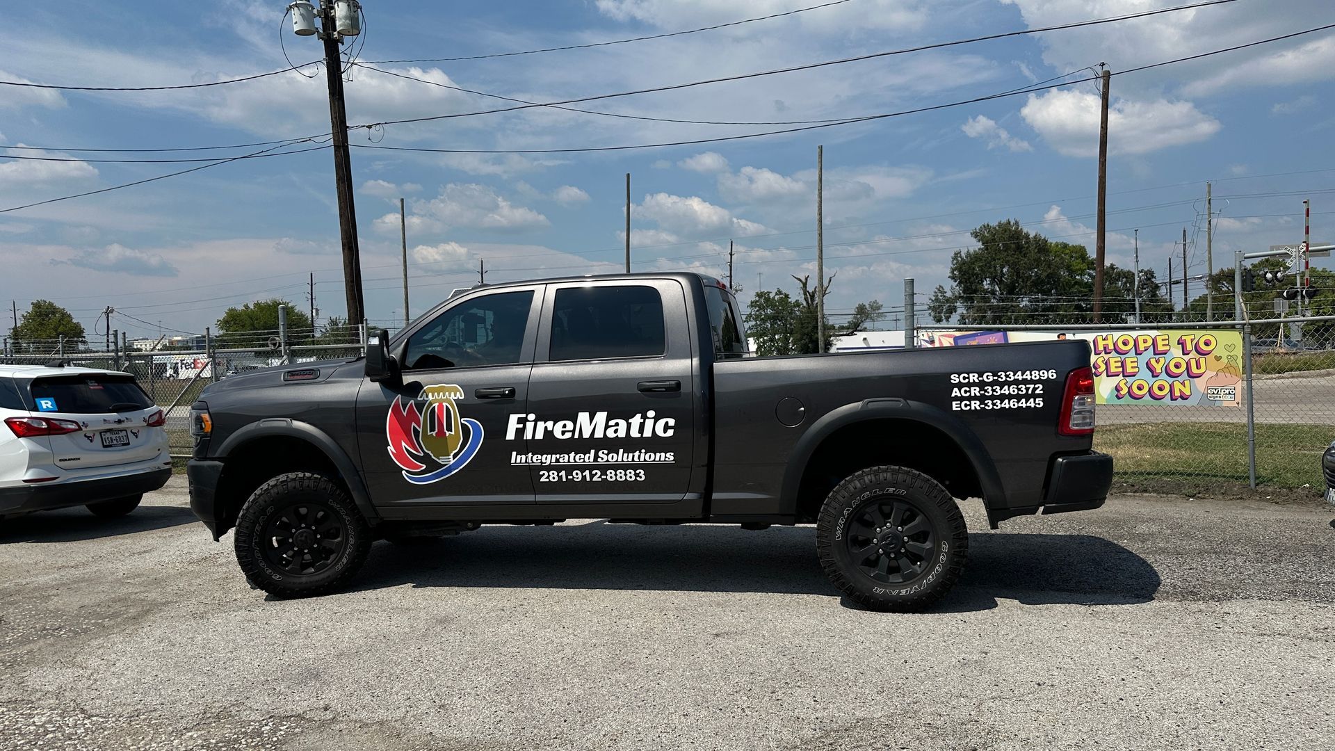 Dark gray Firematic pickup truck parked on gravel.