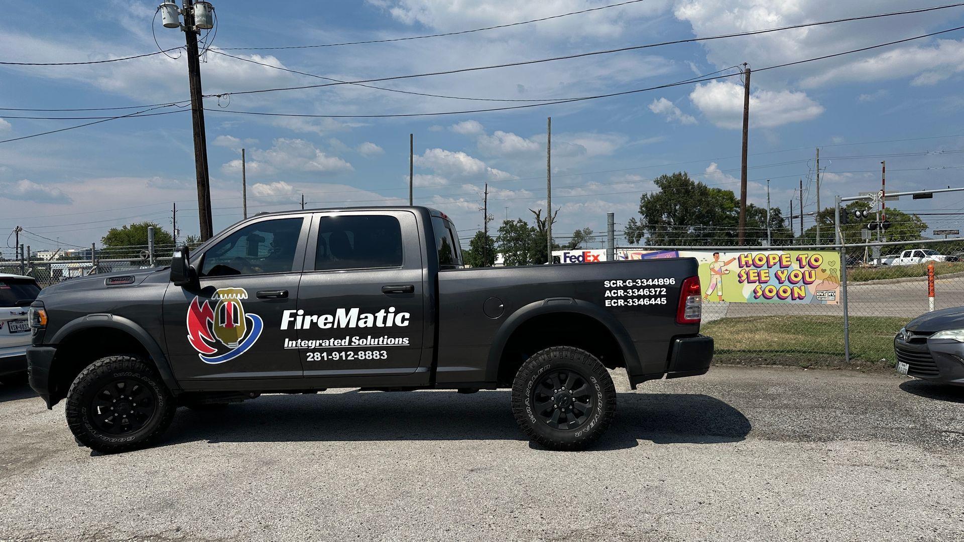 Dark gray Firematic pickup truck parked on gravel.