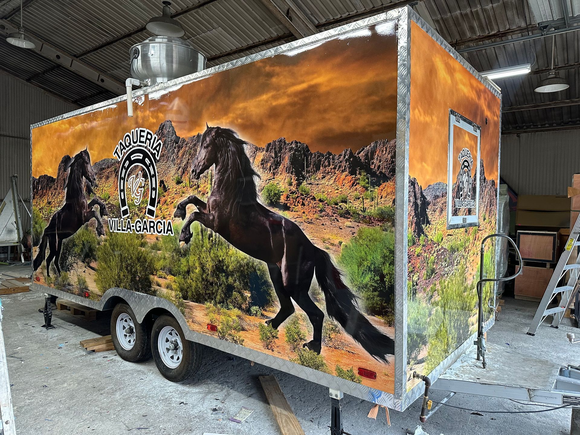 A food trailer with a horse graphic on the side, in a desert landscape setting.