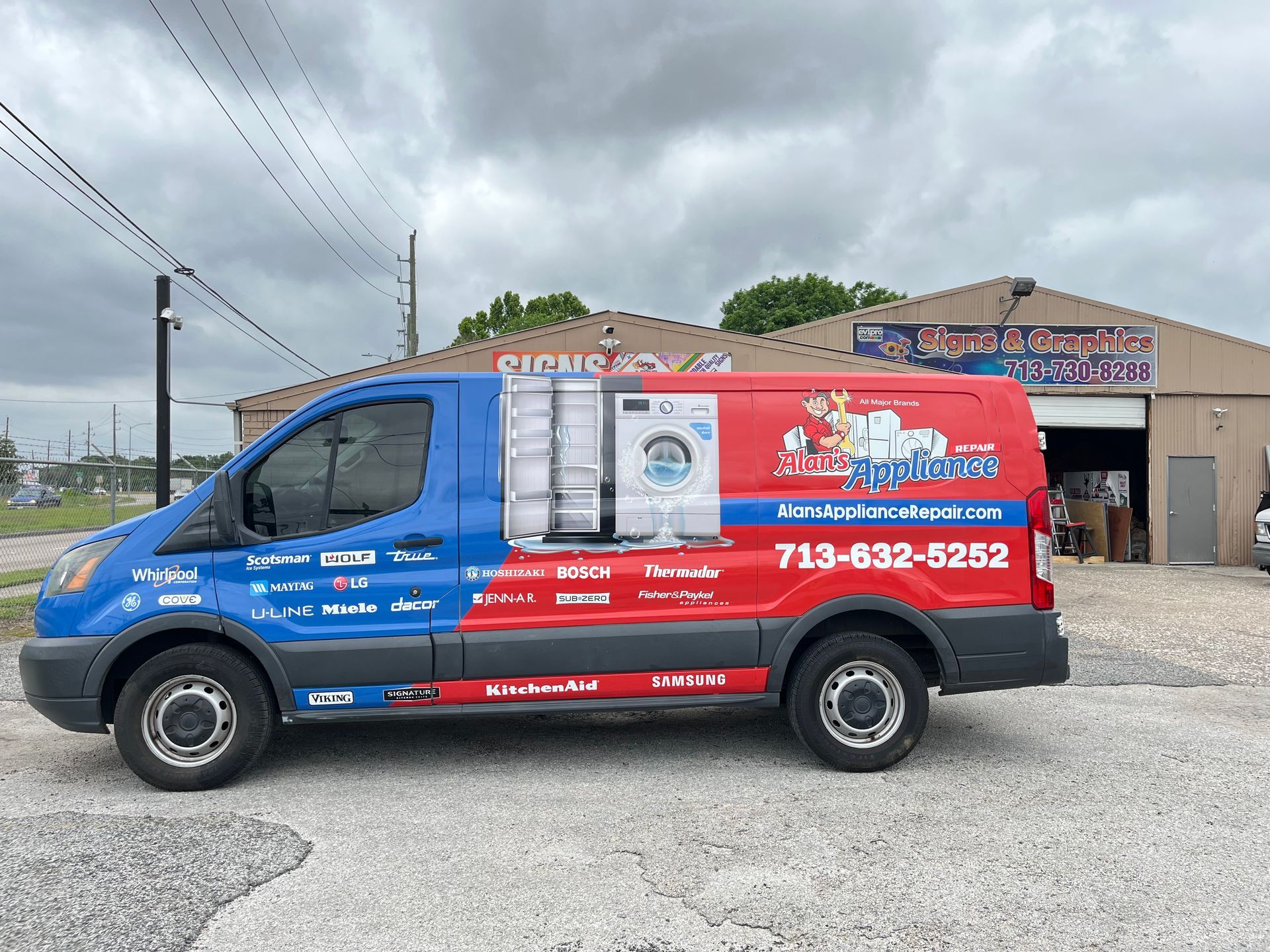 Blue and red delivery van parked outside a business with 
