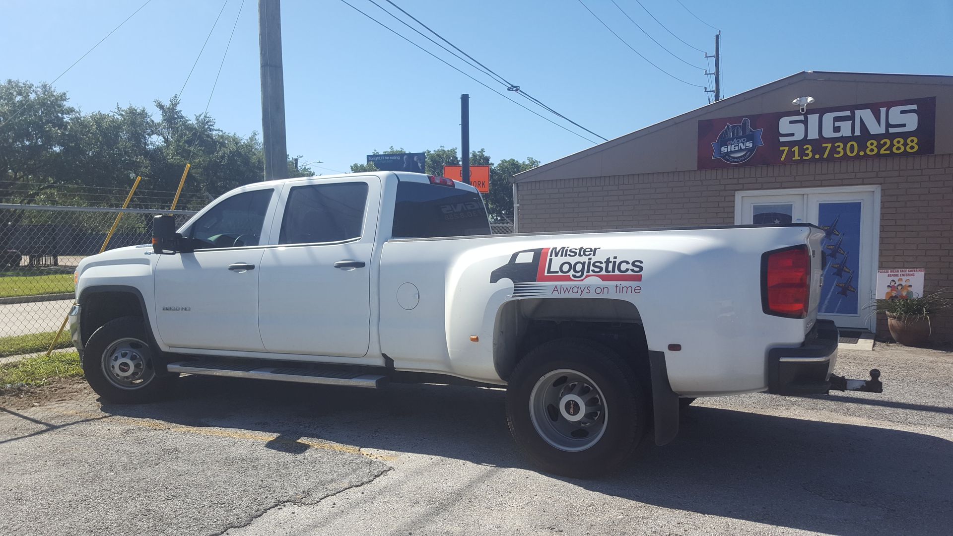White pickup truck with company logo parked outside a building with 