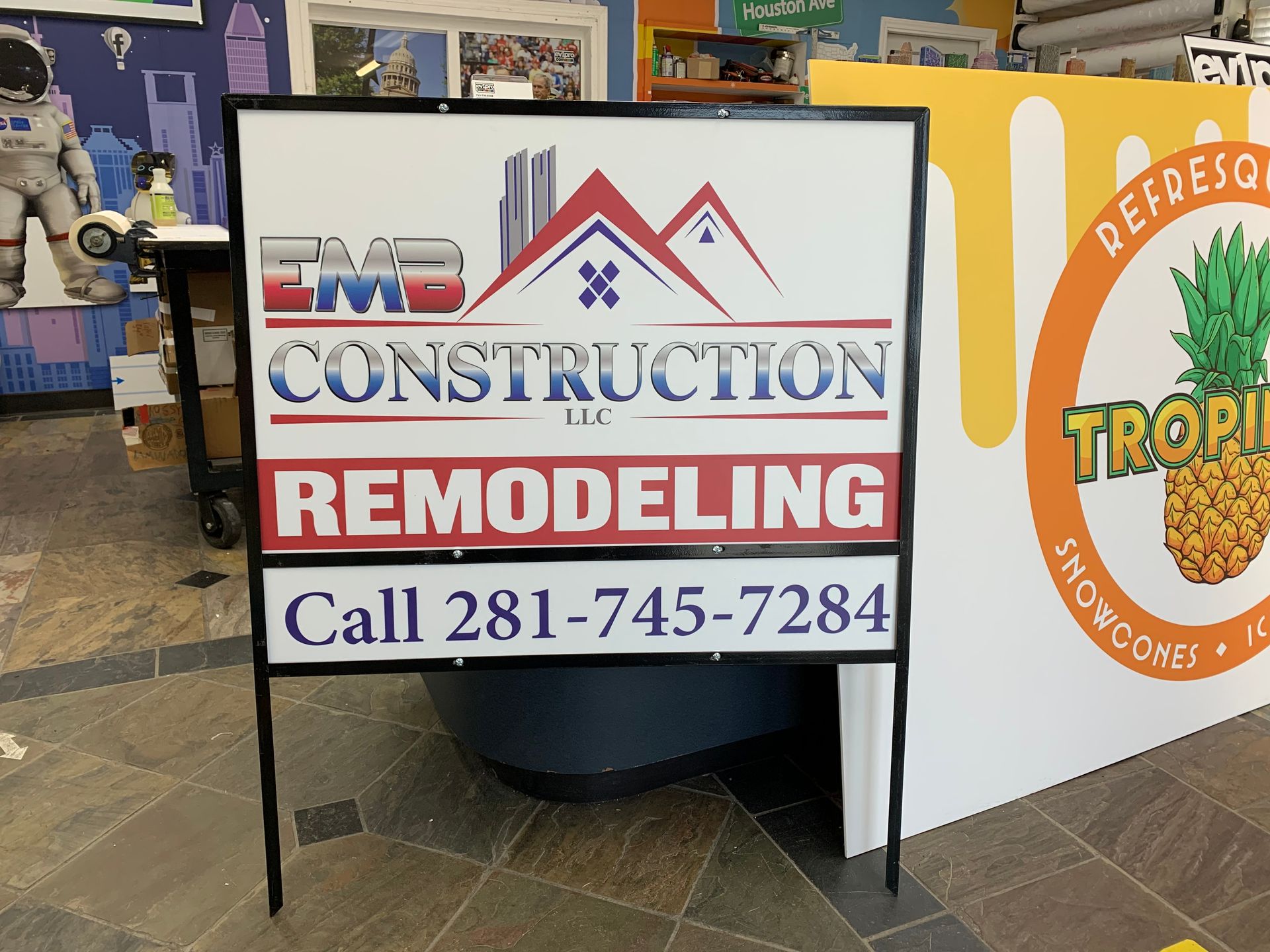 Sign for EMB Construction, Remodeling.  Features logo with red, blue, and white colors, and phone number 281-745-7284.