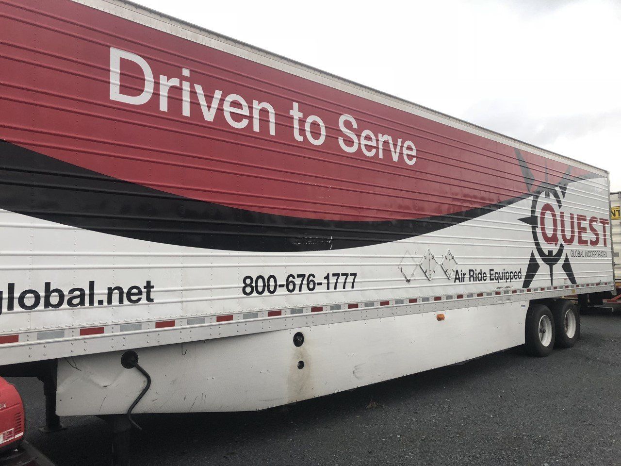 A red and white trailer that says driven to serve