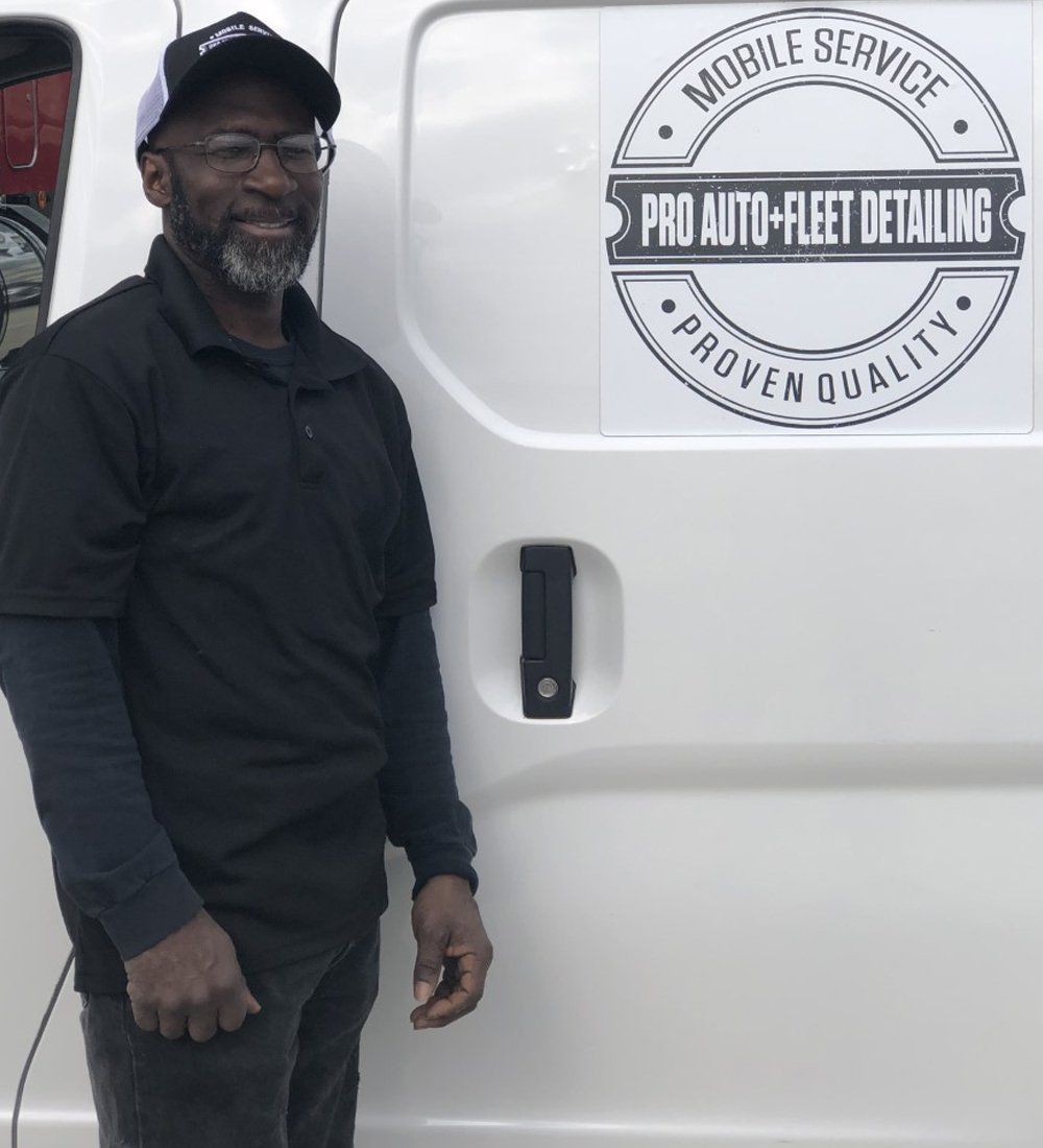A man standing in front of a pro auto fleet detailing van
