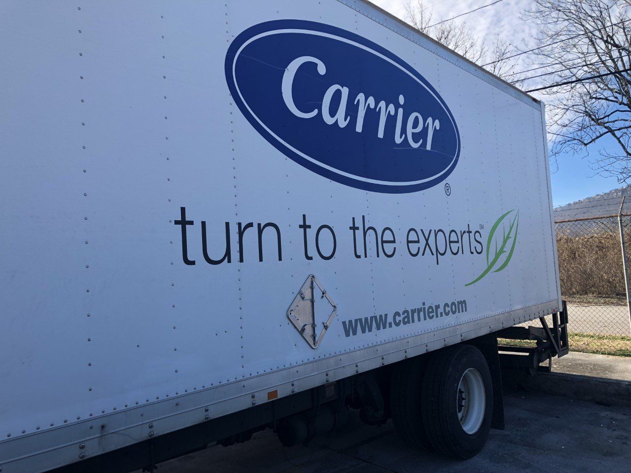 A carrier truck is parked on the side of the road.