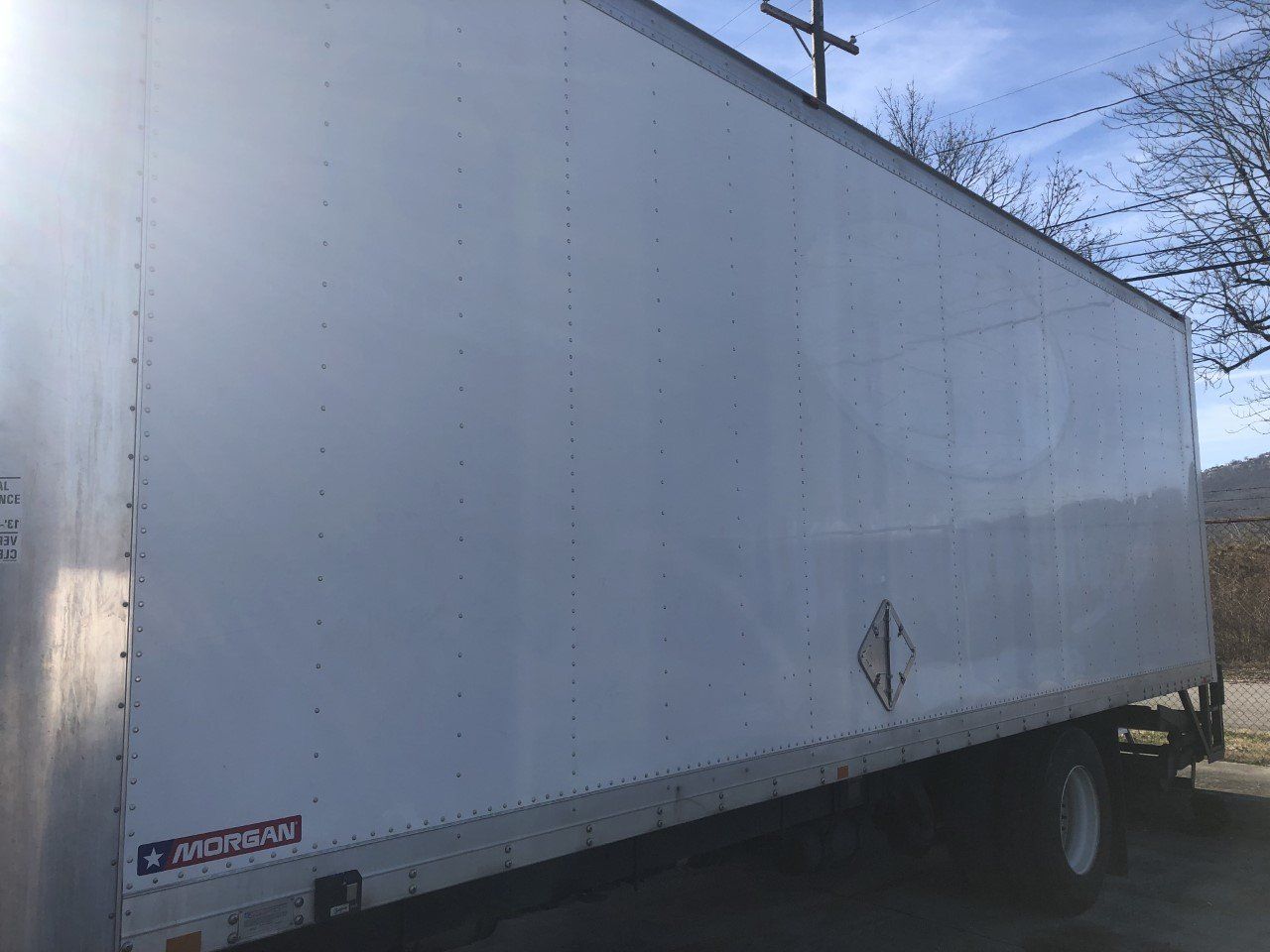 A white box truck is parked on the side of the road.