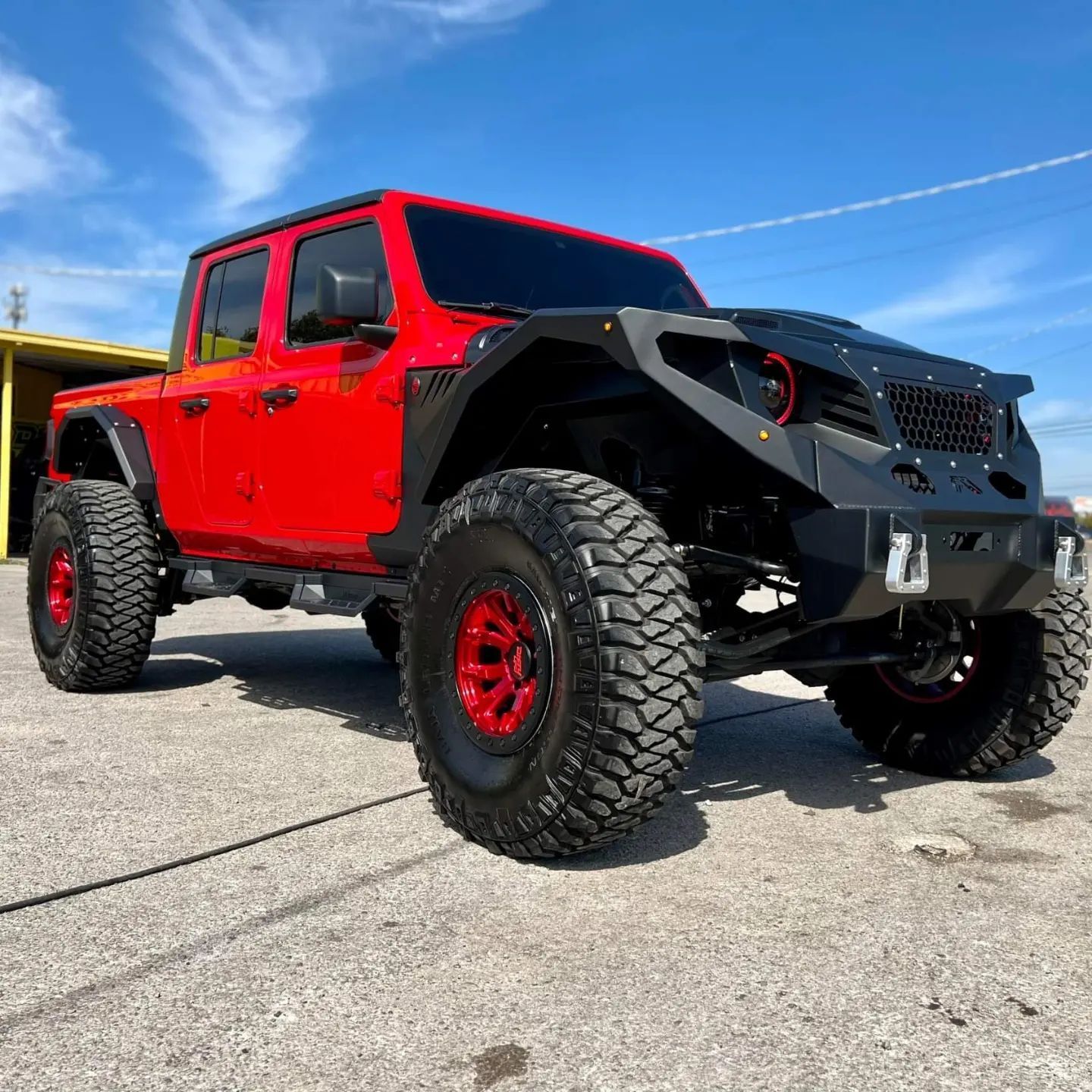 A red jeep is parked on the side of the road.