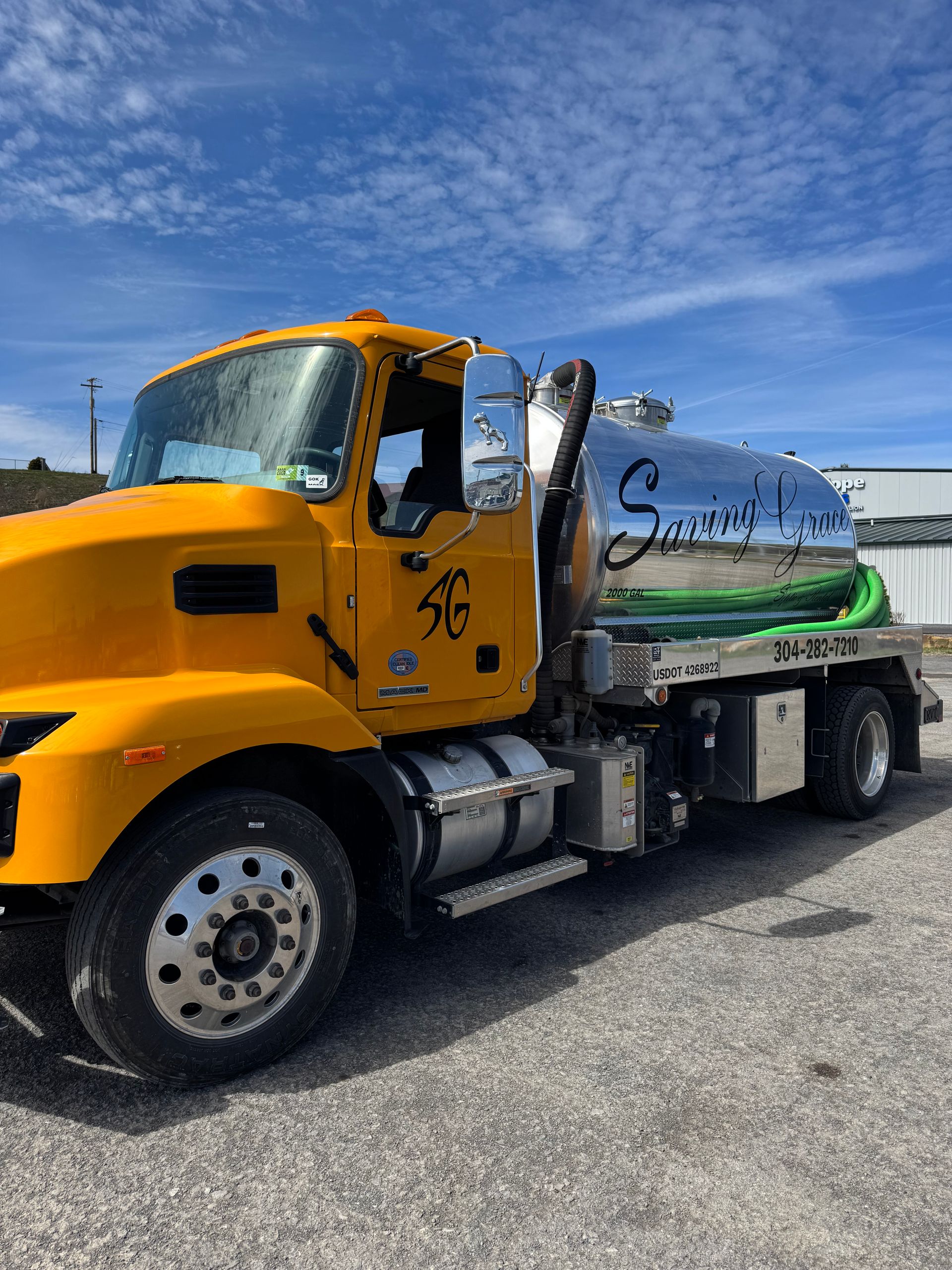 Yellow tanker truck parked outdoors under a blue sky