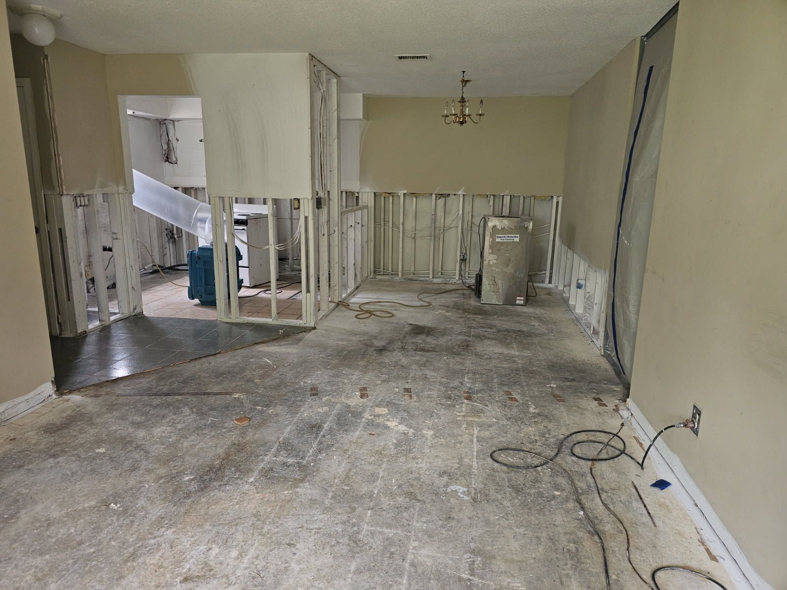 Interior room under renovation; walls and flooring partially removed.
