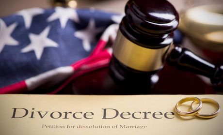 A pair of wedding rings sit on top of a divorce decree