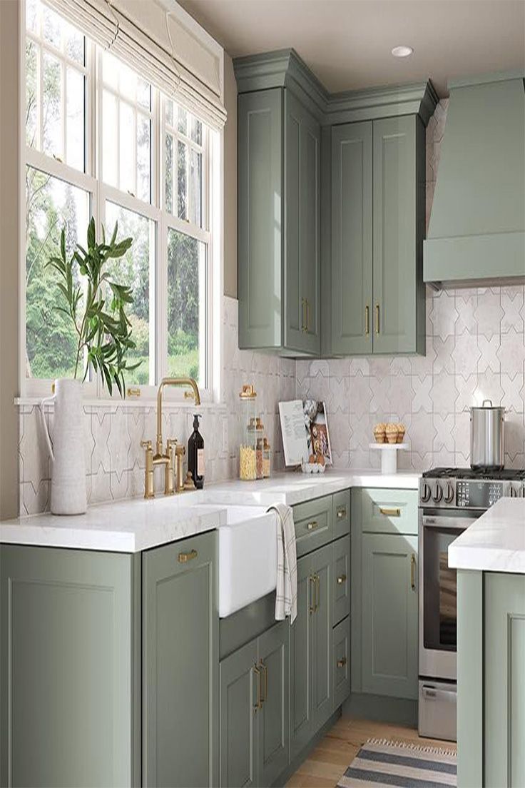 Soft sage-green kitchen with white countertops, farmhouse sink, large window, and stove by tiled backsplash