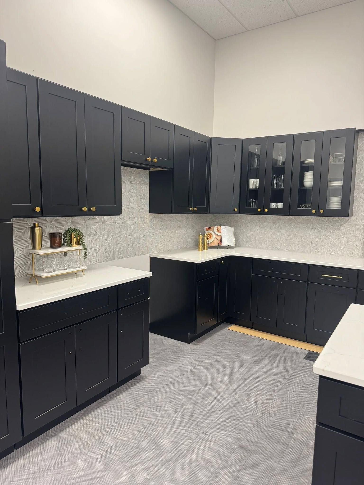 Modern kitchen with dark cabinets, white countertops, and a light gray tile floor