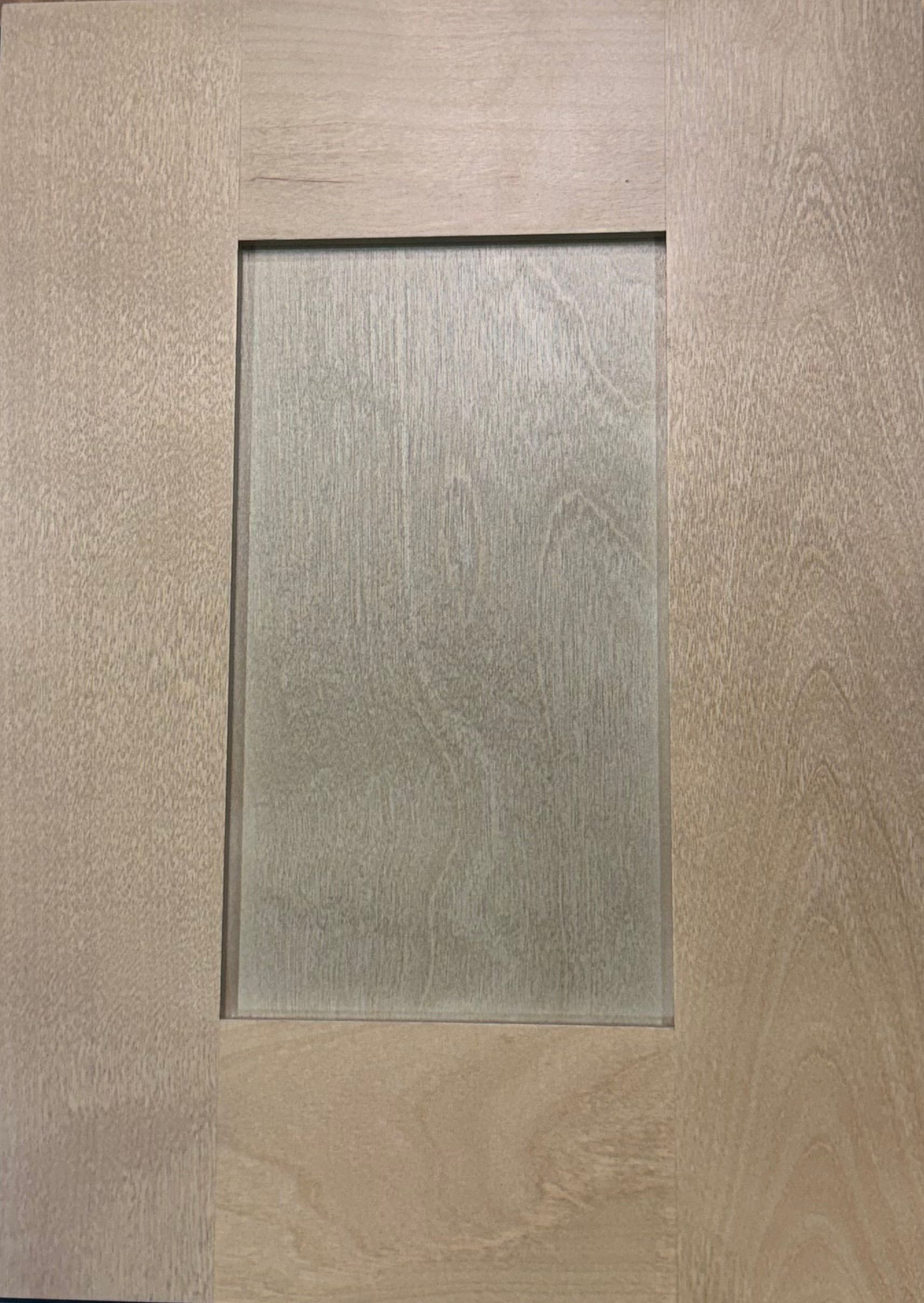 Close-up of a wooden cabinet door with a framed, recessed panel of a lighter tone wood.