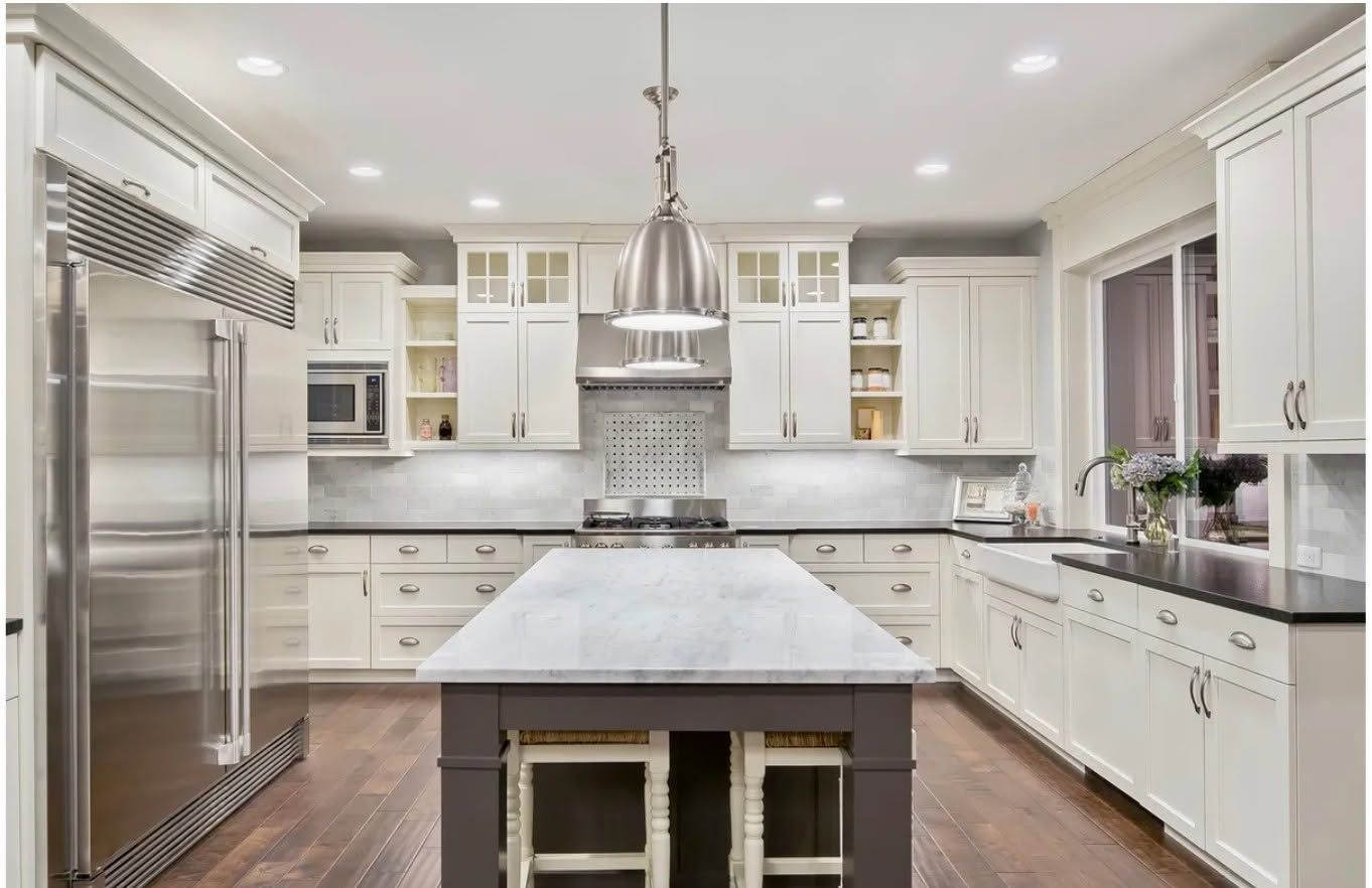 Bright modern white kitchen with stainless steel appliances and a large marble island