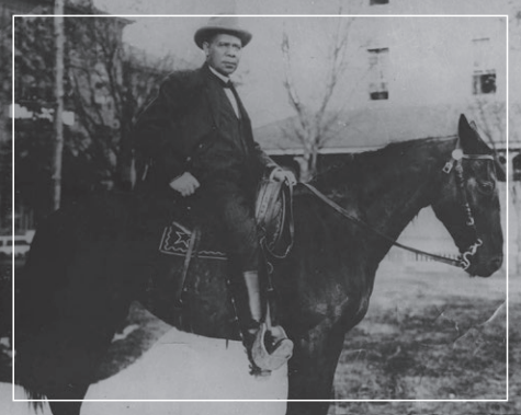 Person on horseback in a snowy outdoor scene, wearing a hat and dark coat.