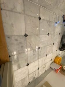 White marble tile wall with black diamond accents.