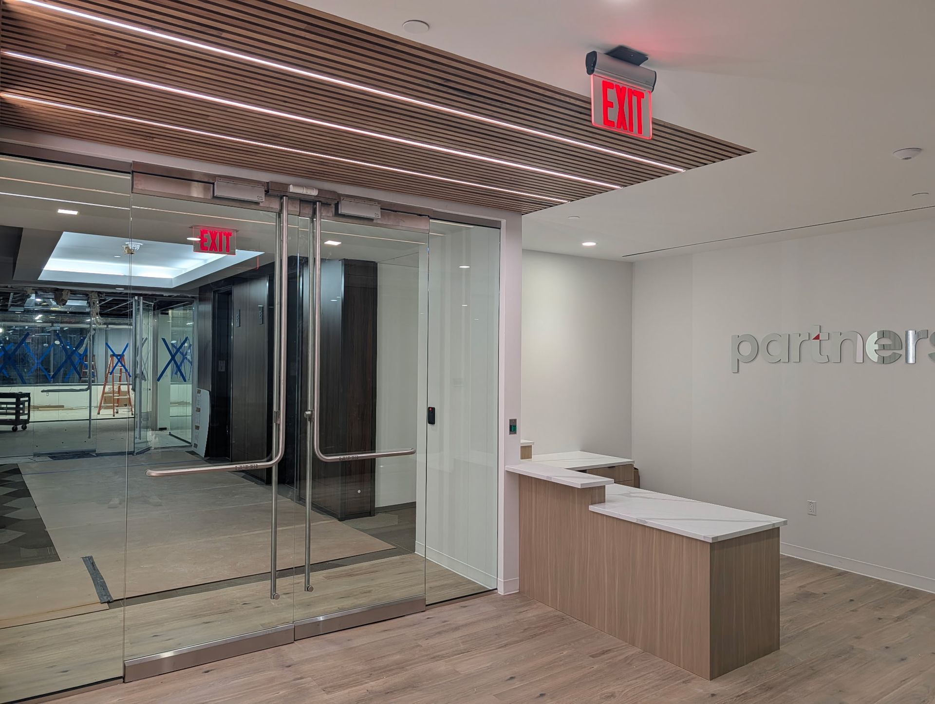 Office entrance with glass doors, a reception desk, and