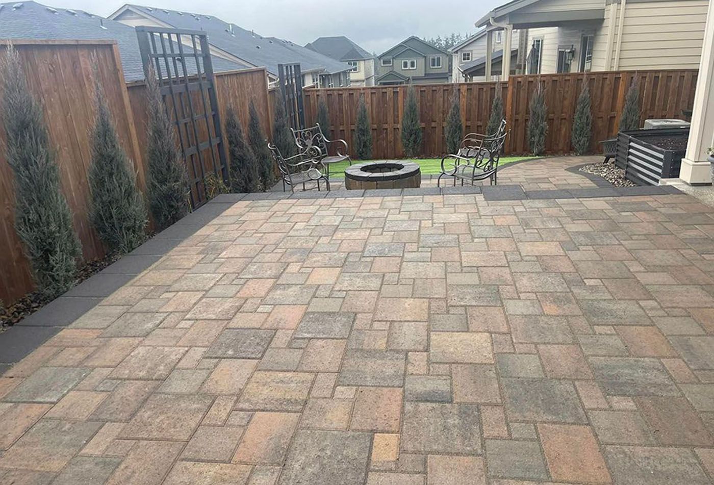 A fire pit in the backyard with a brick patio