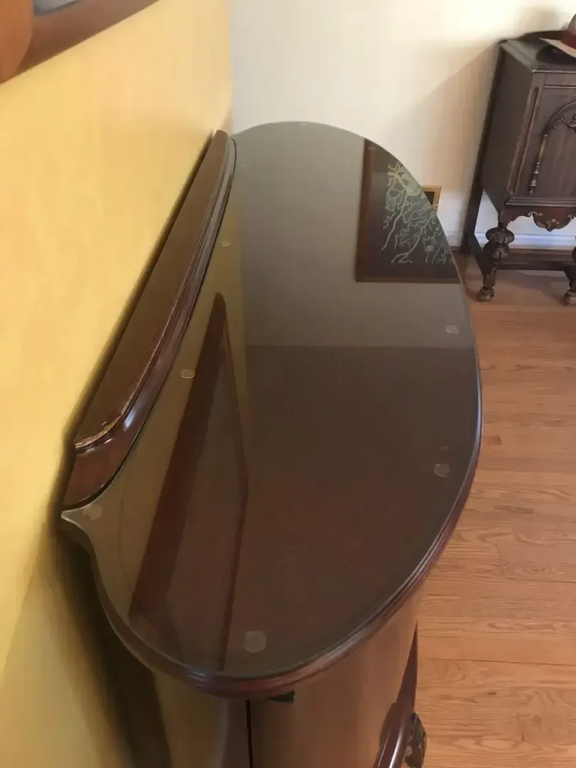 A black dresser with a glass top in a room