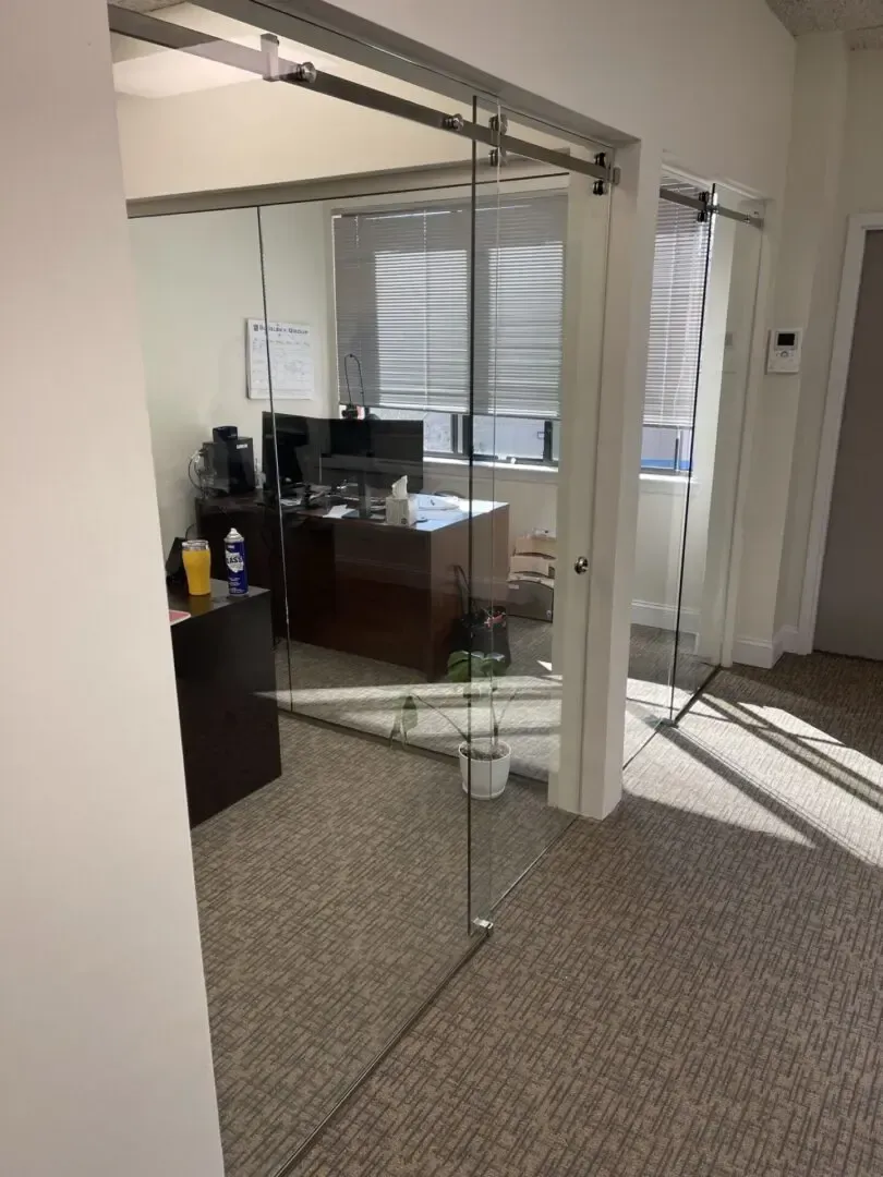 A room with a glass door and a desk in it.