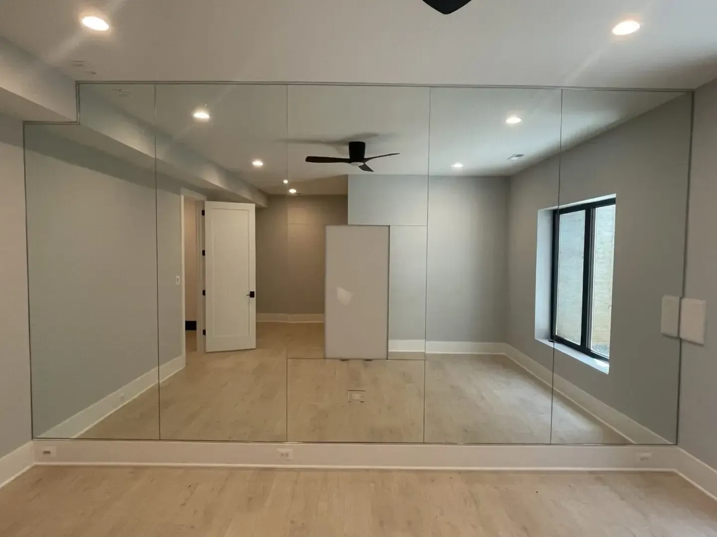 An empty room with a large mirror on the wall.