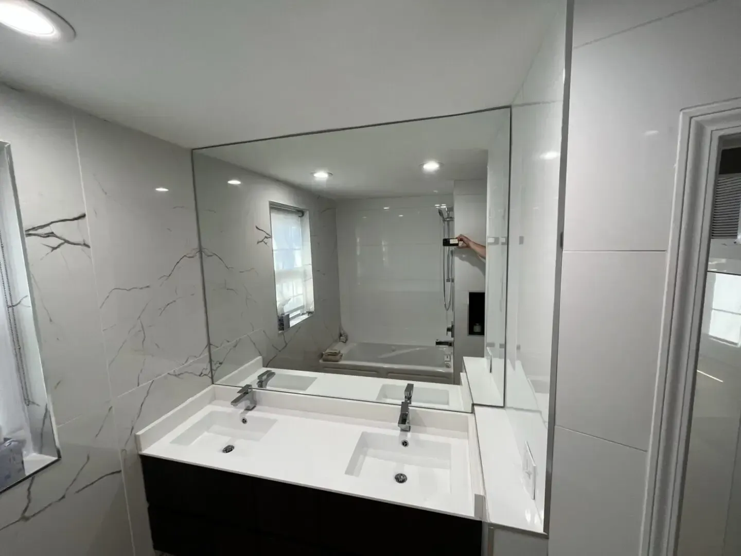 A bathroom with two sinks and a large mirror.