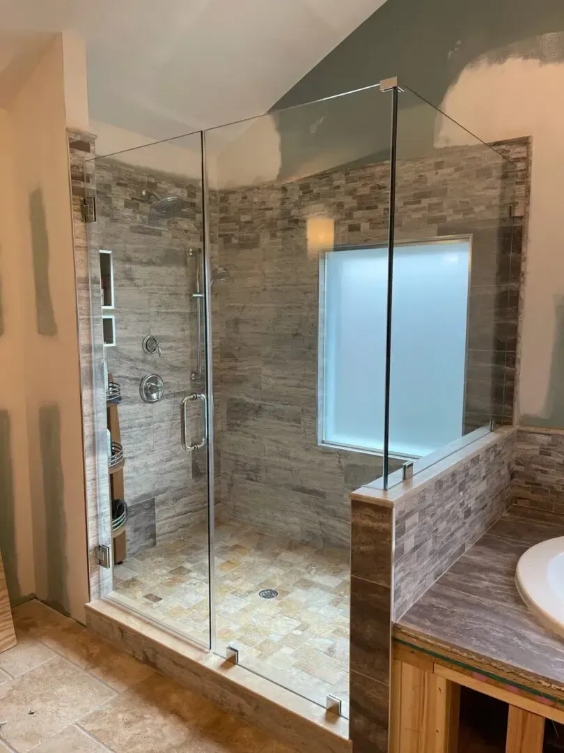 A bathroom with a walk in shower and a sink.