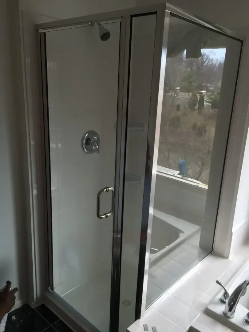 A bathroom with a walk in shower and a tub