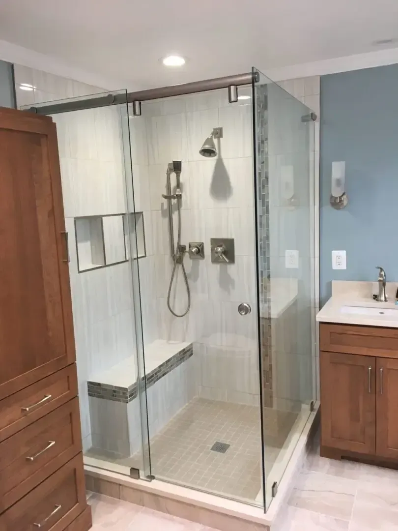 A bathroom with a sliding glass shower door and a sink.