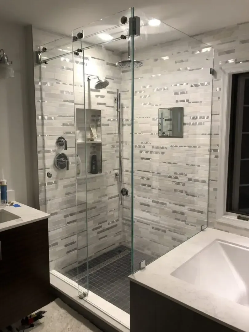 A bathroom with a walk in shower and a sink.