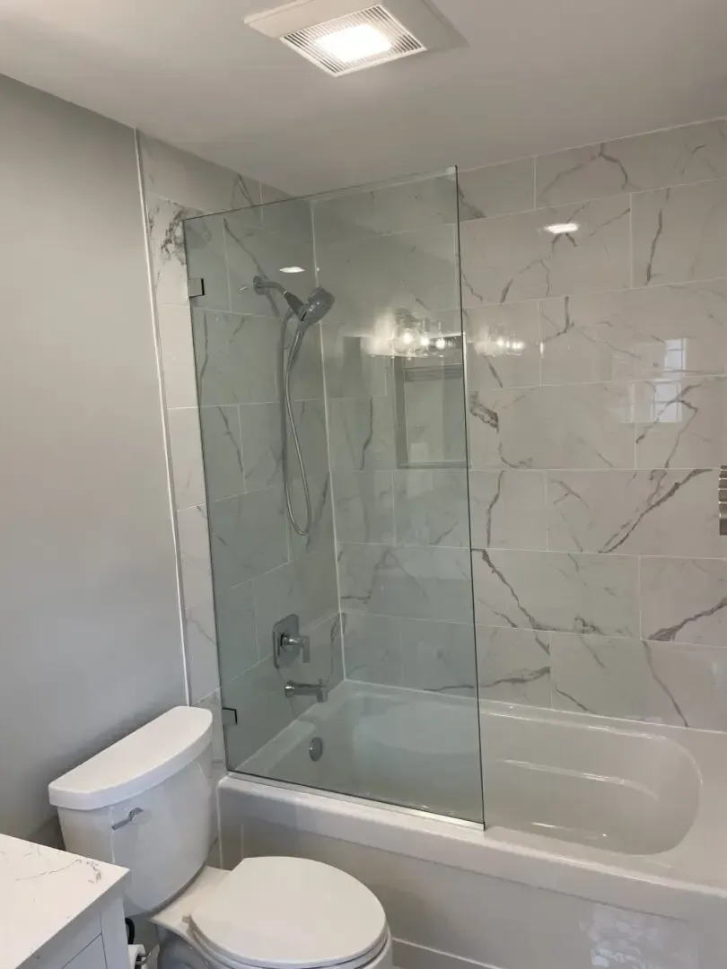 A bathroom with a toilet , bathtub and shower.