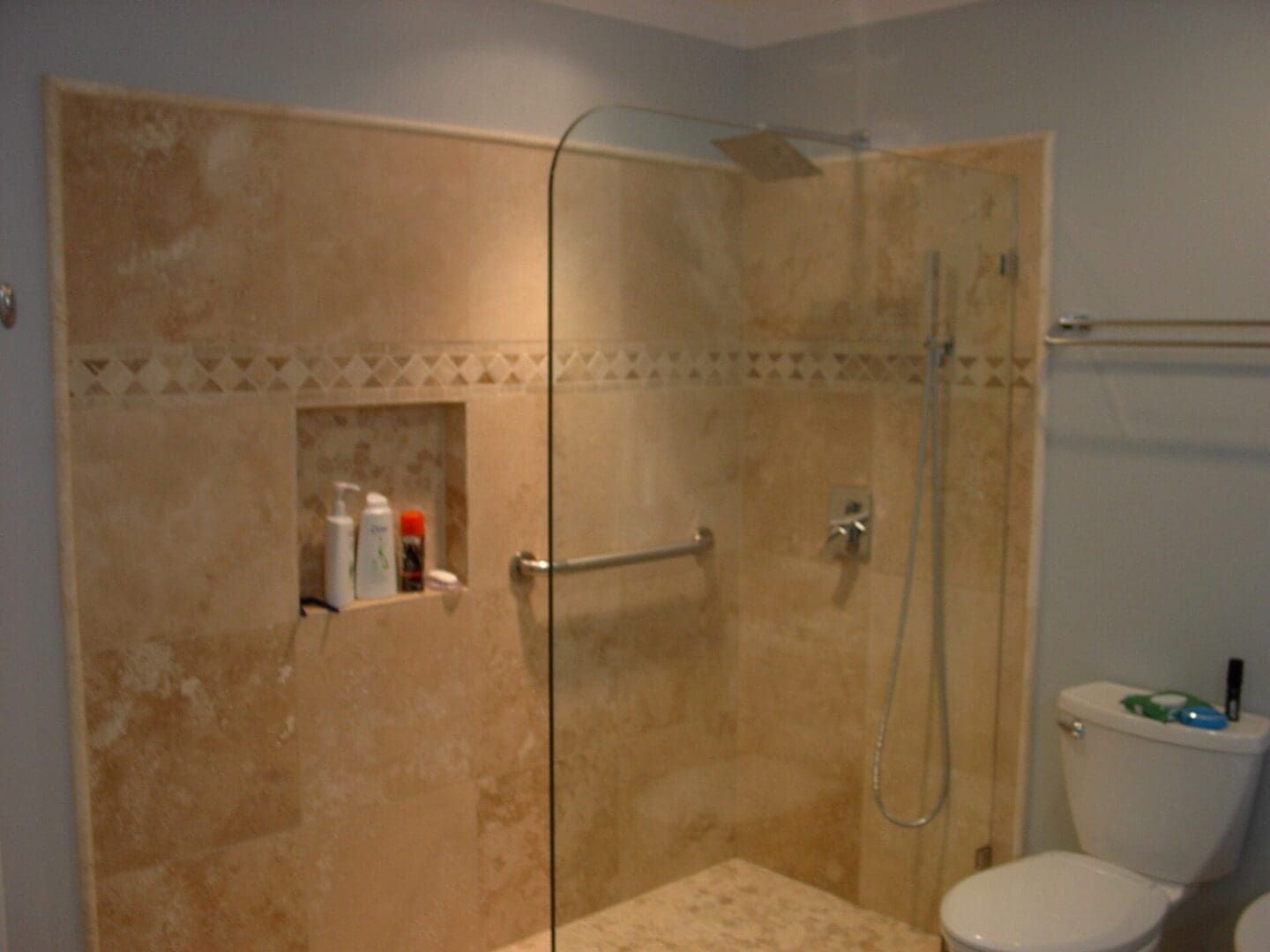 A bathroom with a walk in shower and a toilet