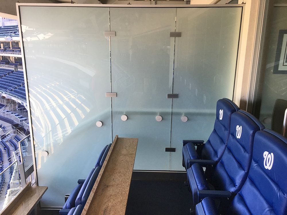 A stadium with blue seats and a glass wall