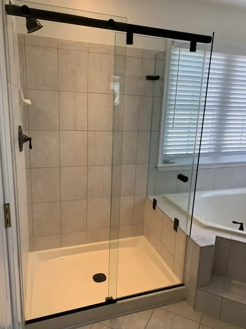 A bathroom with a walk in shower and a tub